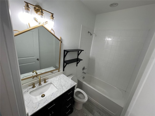 full bathroom featuring wood-type flooring, vanity, toilet, and tiled shower / bath