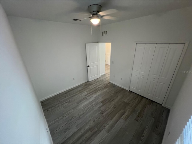 unfurnished bedroom featuring ceiling fan, dark hardwood / wood-style floors, and a closet