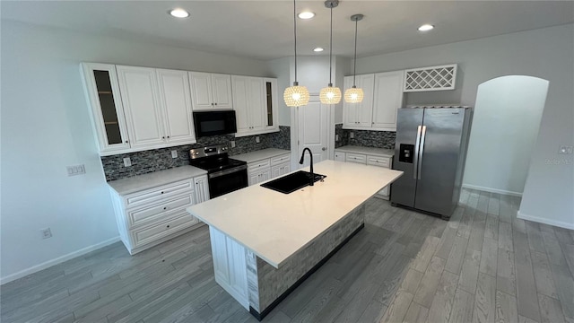 kitchen with sink, a center island with sink, hanging light fixtures, and appliances with stainless steel finishes