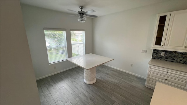 unfurnished dining area featuring dark hardwood / wood-style flooring and ceiling fan