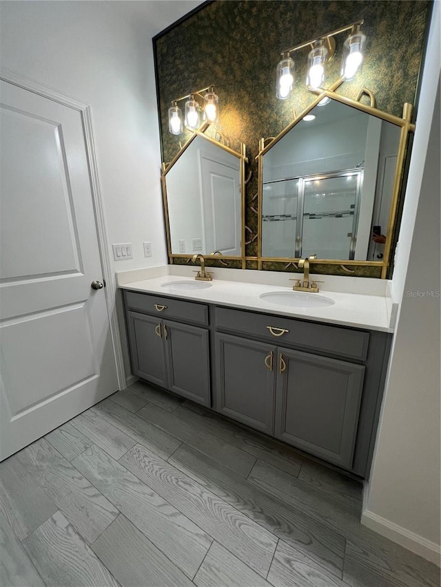 bathroom with hardwood / wood-style floors, vanity, and an enclosed shower