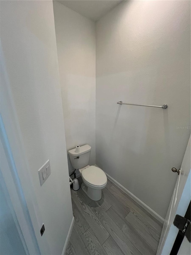 bathroom with hardwood / wood-style floors and toilet