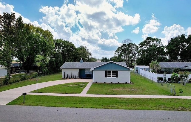 view of front of property featuring a front yard, concrete driveway, and fence