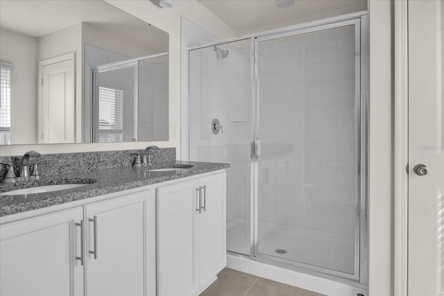 bathroom with vanity, a shower with shower door, and tile patterned flooring