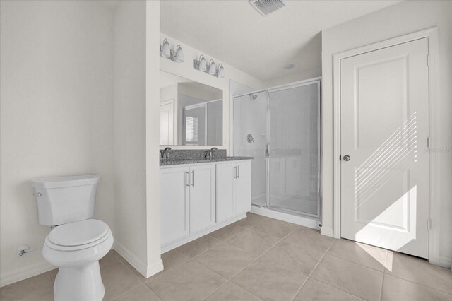 bathroom with vanity, tile patterned floors, toilet, and an enclosed shower