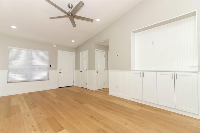 spare room with light hardwood / wood-style floors, vaulted ceiling, and ceiling fan