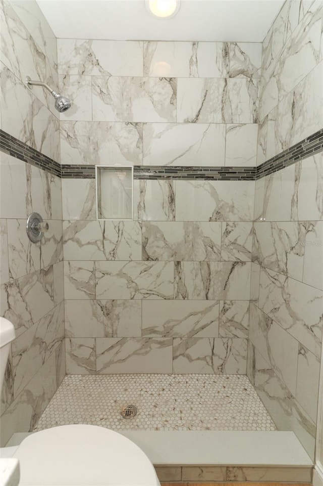 bathroom featuring toilet and tiled shower