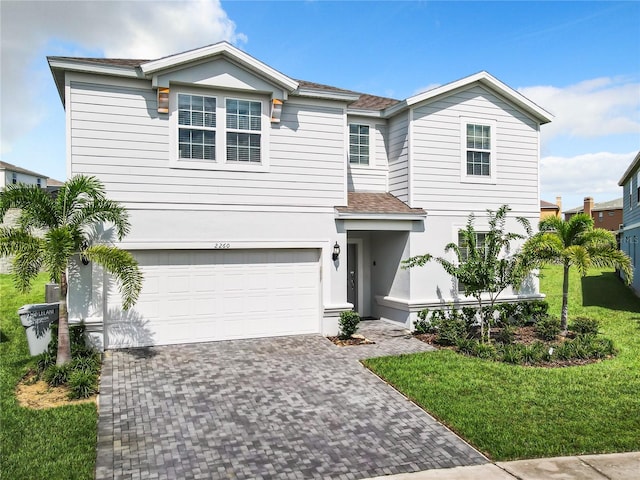 view of front of property featuring a front lawn and a garage