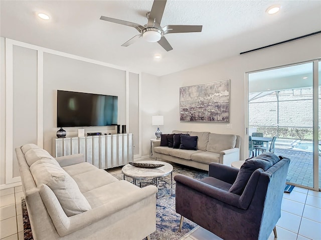 living room featuring ceiling fan, light tile patterned floors, and a textured ceiling