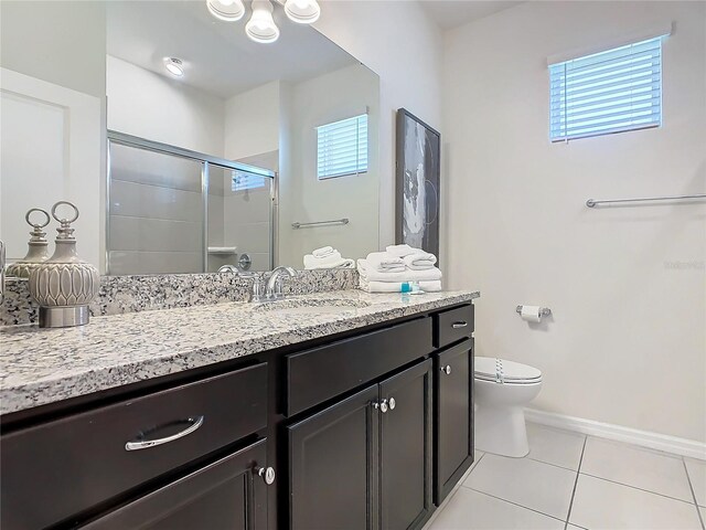 bathroom featuring walk in shower, vanity, toilet, and tile patterned floors