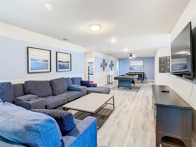 living room featuring light wood-type flooring, ceiling fan, billiards, and a textured ceiling