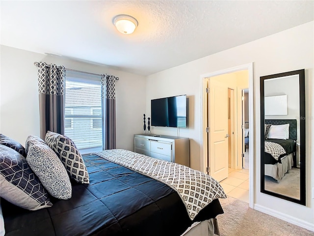 bedroom featuring light carpet and a textured ceiling