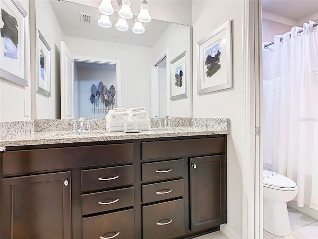 bathroom featuring walk in shower, vanity, toilet, and tile patterned floors