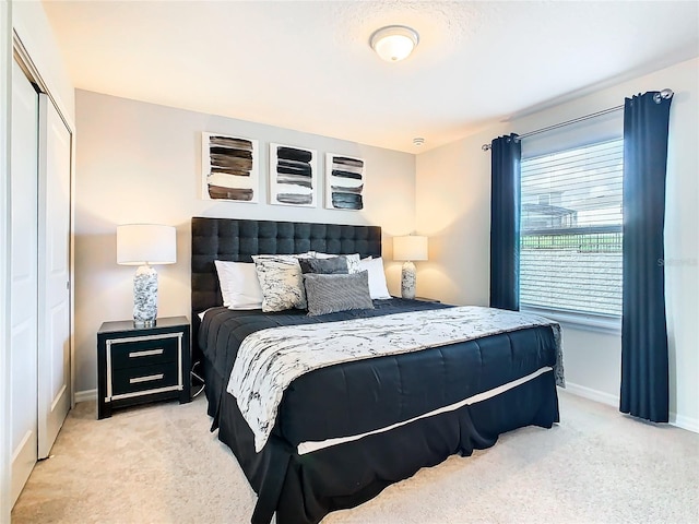 bedroom featuring a closet and light colored carpet