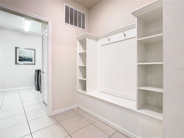 mudroom featuring separate washer and dryer and light tile patterned floors