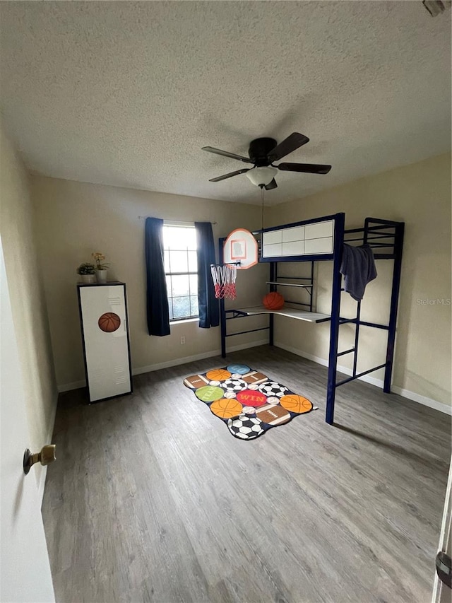 bedroom featuring a textured ceiling, ceiling fan, and hardwood / wood-style flooring