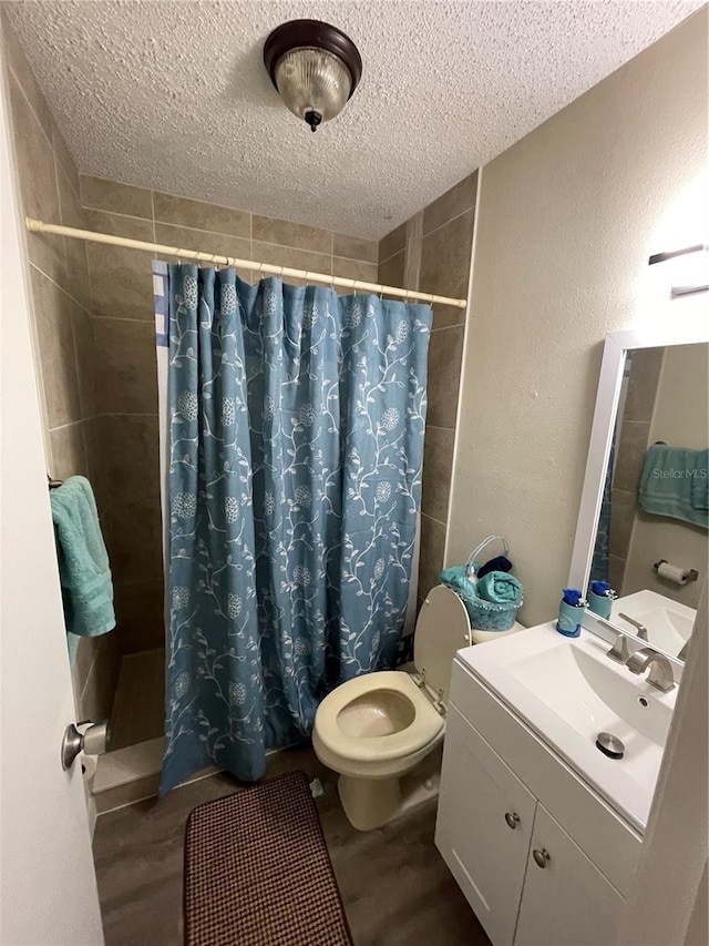 bathroom featuring curtained shower, vanity, a textured ceiling, wood-type flooring, and toilet