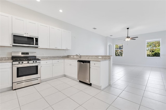 kitchen with white cabinets, ceiling fan, light stone counters, and stainless steel appliances