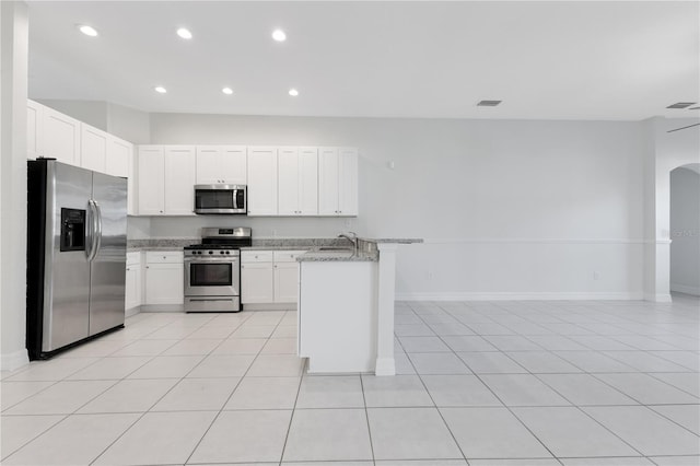 kitchen featuring white cabinetry, light stone counters, light tile patterned flooring, and stainless steel appliances