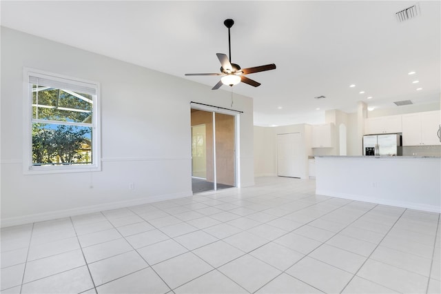 empty room with light tile patterned floors and ceiling fan