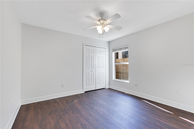 empty room with ceiling fan and dark wood-type flooring