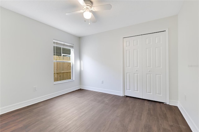 unfurnished bedroom with ceiling fan, a closet, and dark hardwood / wood-style floors