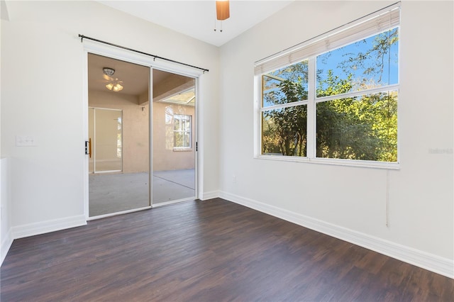 unfurnished bedroom featuring ceiling fan, multiple windows, dark wood-type flooring, and a closet