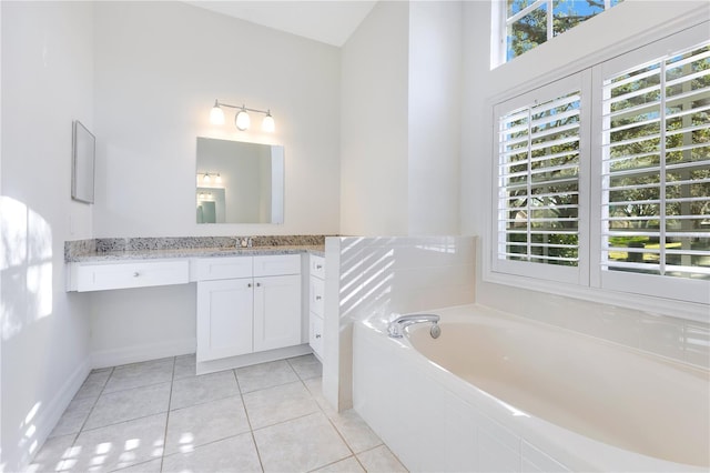 bathroom featuring vanity, a relaxing tiled tub, and tile patterned floors