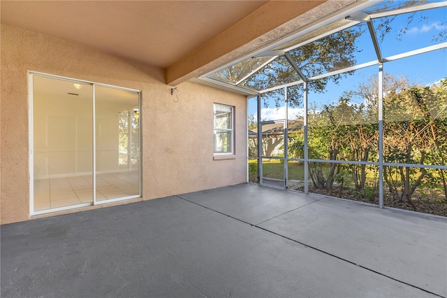 unfurnished sunroom featuring beam ceiling