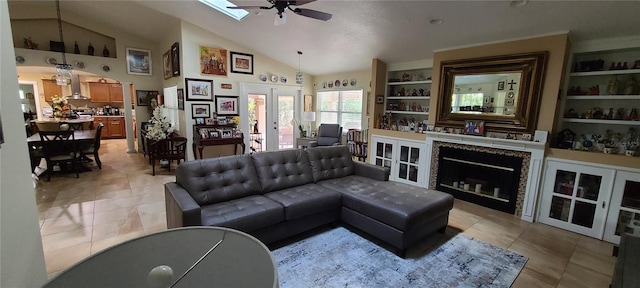 living room with french doors, a skylight, ceiling fan, built in features, and light tile patterned flooring