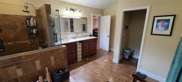 bathroom with tiled shower and vanity