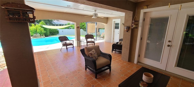 view of patio featuring ceiling fan, fence, a fenced in pool, and french doors