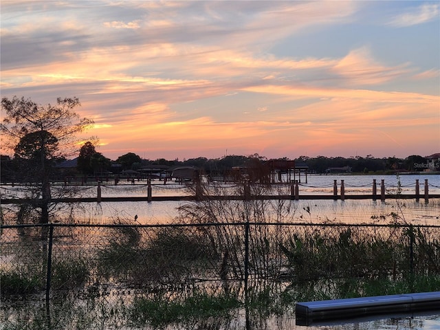 water view featuring a dock and fence