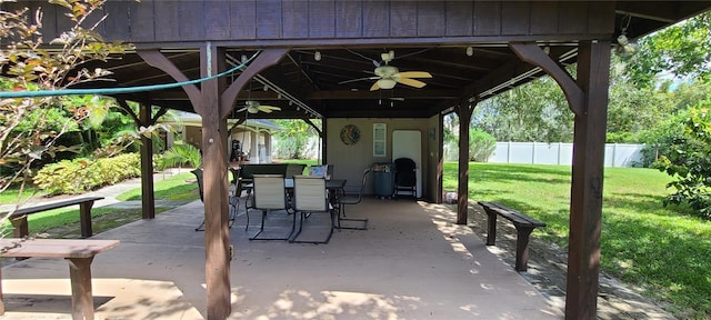 view of patio with outdoor dining space, fence, and a ceiling fan