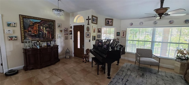 sitting room with lofted ceiling, a healthy amount of sunlight, baseboards, and ceiling fan with notable chandelier