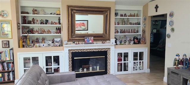 interior space with built in features, a tiled fireplace, and french doors