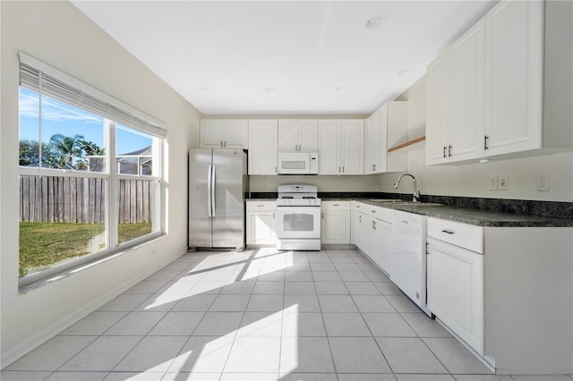 kitchen featuring white cabinets, light tile patterned floors, white appliances, and sink