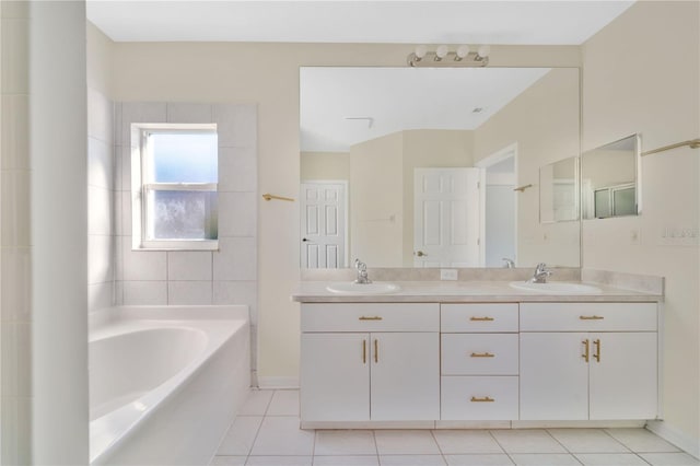 bathroom with a bathing tub, tile patterned flooring, and vanity