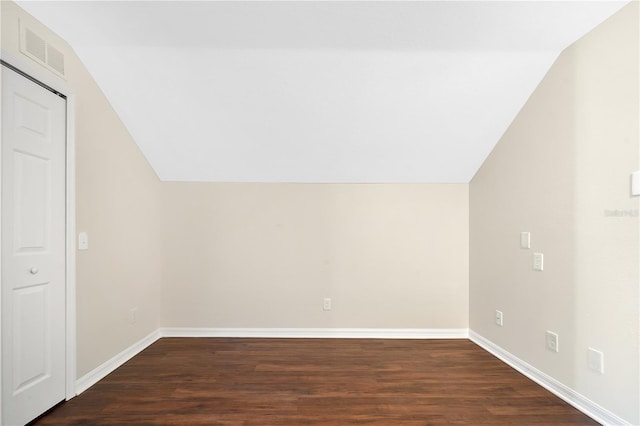 additional living space with dark hardwood / wood-style flooring and vaulted ceiling