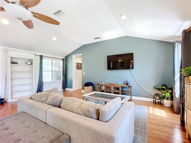 living room with ceiling fan, vaulted ceiling, and light hardwood / wood-style flooring