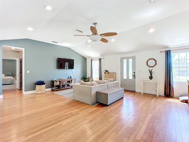 living room featuring vaulted ceiling, ceiling fan, and light hardwood / wood-style flooring