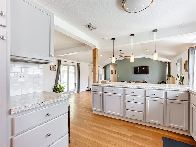 kitchen featuring vaulted ceiling with beams, tasteful backsplash, light hardwood / wood-style flooring, pendant lighting, and white cabinets