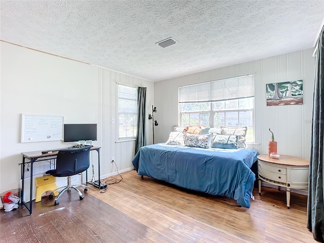 bedroom with wood-type flooring and a textured ceiling