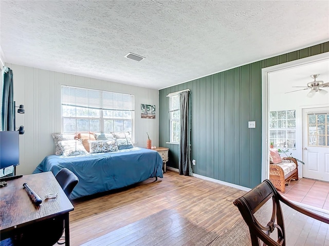 bedroom with wood-type flooring and a textured ceiling