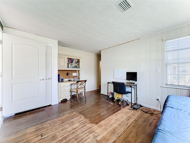 office area with dark hardwood / wood-style floors and a textured ceiling