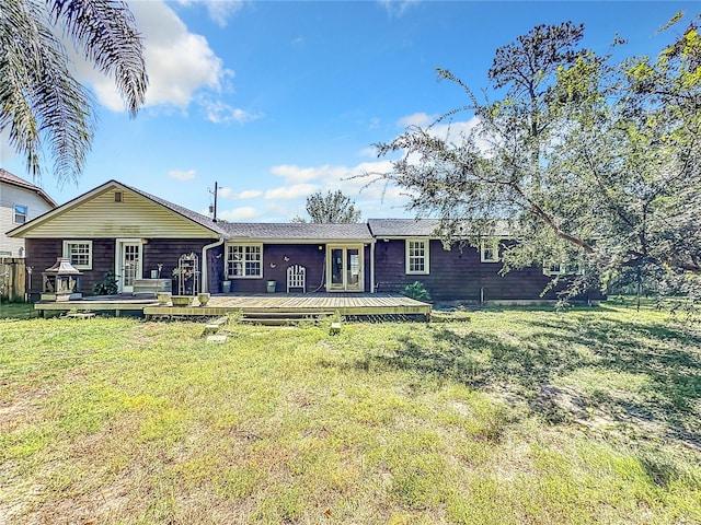 ranch-style home featuring a wooden deck and a front yard