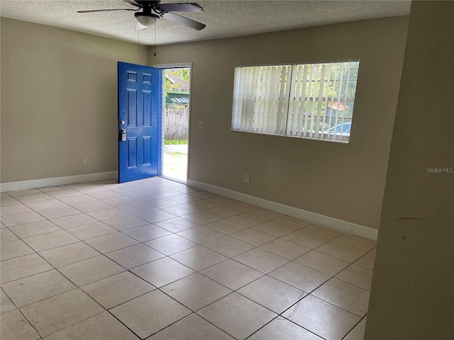 tiled spare room with ceiling fan and a textured ceiling