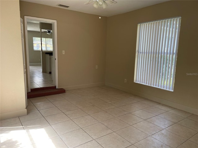 empty room with ceiling fan and light tile patterned flooring