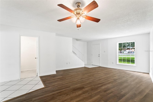 unfurnished room featuring wood-type flooring, ceiling fan, and a textured ceiling