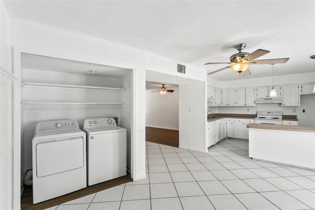 laundry room with ceiling fan, sink, washer and dryer, and light tile patterned flooring